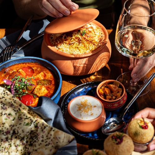 Biryani in a clay pot with curries, naan and wine at Rivayat Creative Indian in Charleston