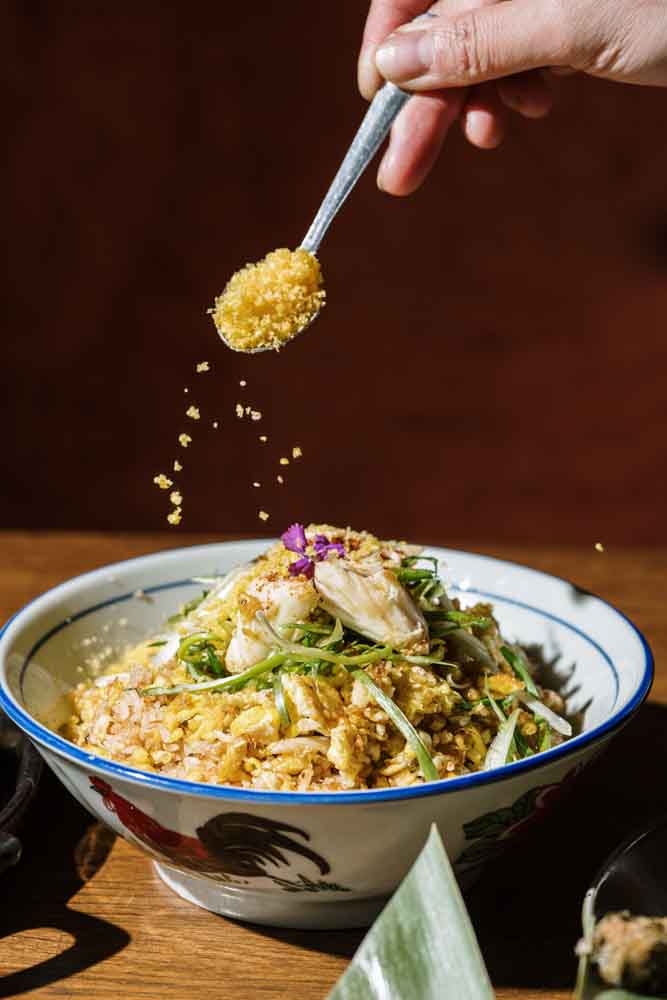 A spoonful of crispy topping sprinkled over a noodle bowl at Tipsy Thaiger in Roswell