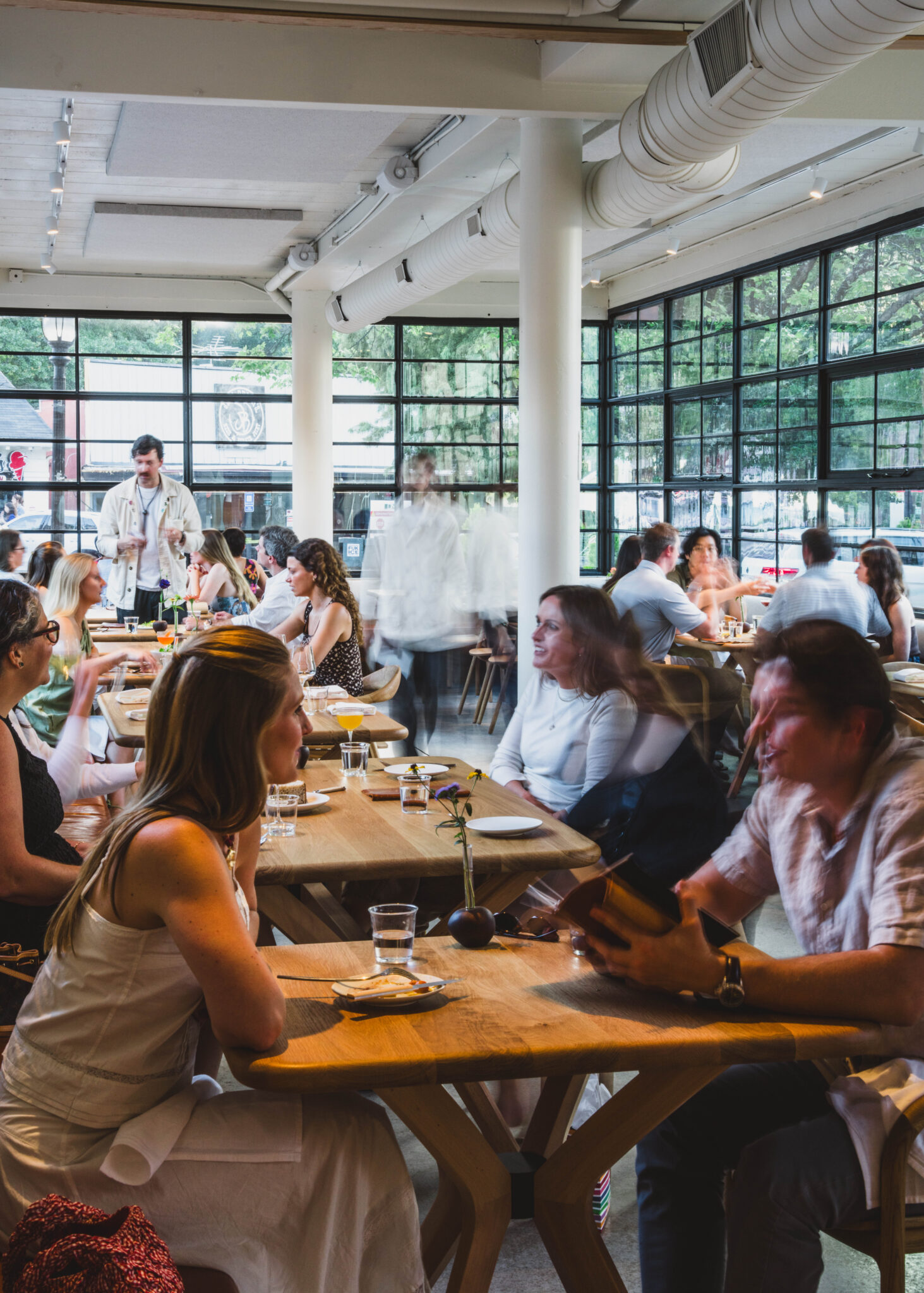 Diners at wooden tables in the bright, window-lined dining room at So. Fox in Virginia-Highland