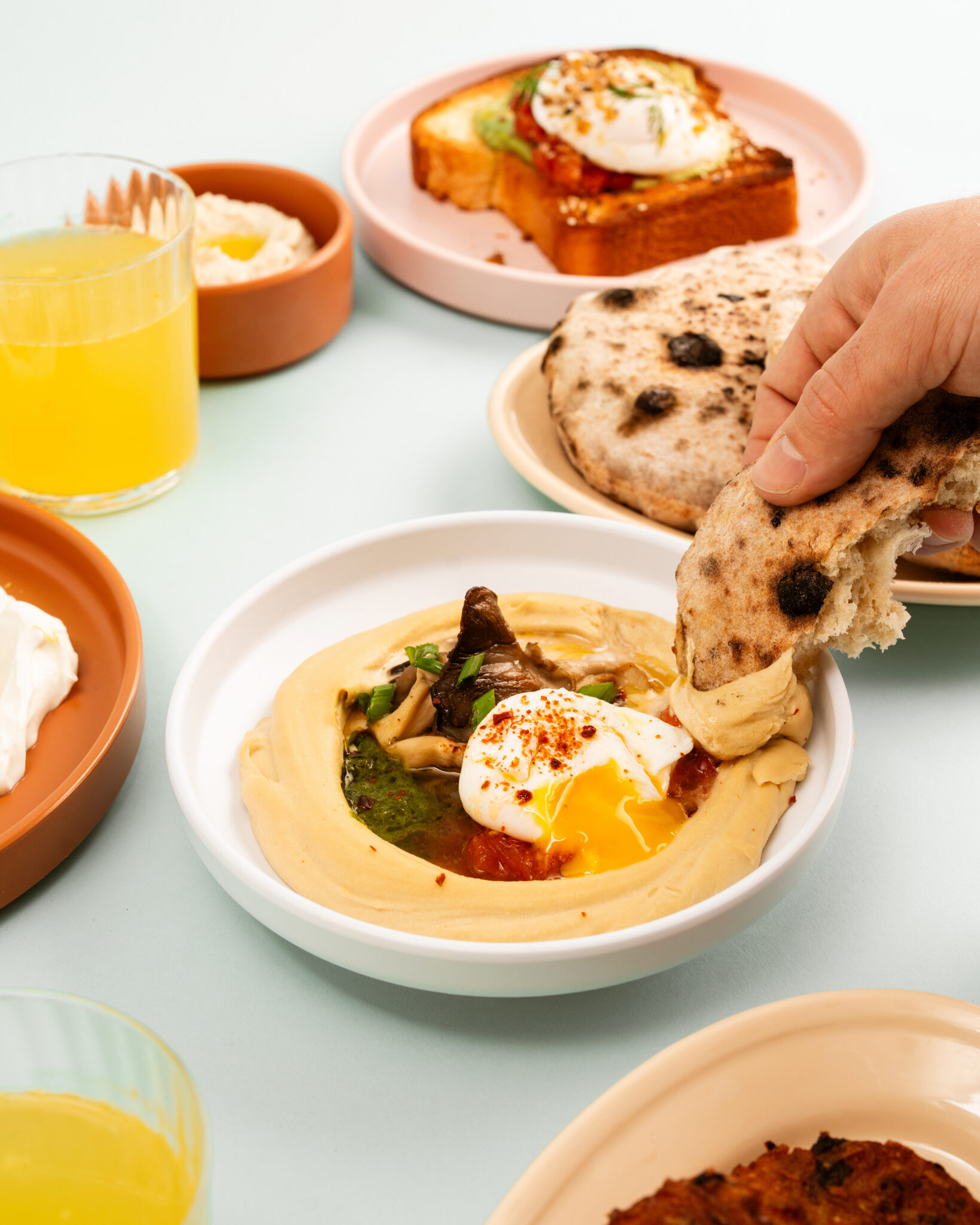 Hummus, fried eggs and toast shared around the table at Safta’s Table in New Orleans